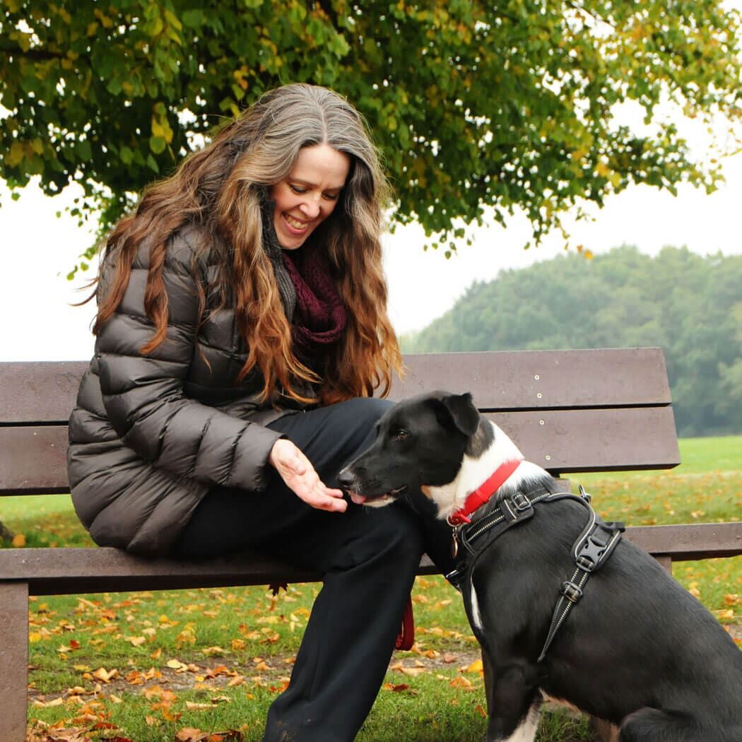 Niki sitting on a bench in a park with Bodie