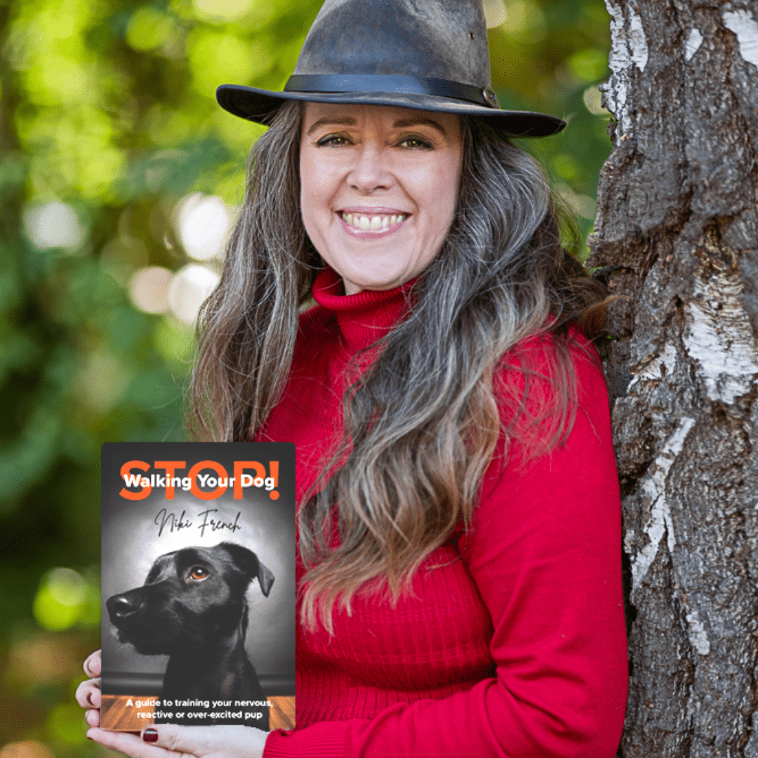 Niki French with black hat posing with book