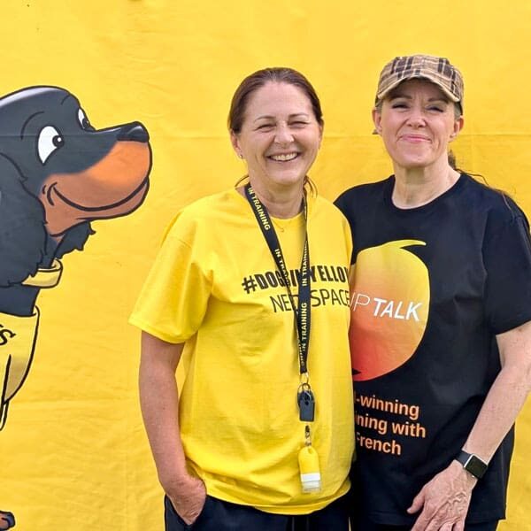 Sarah and Niki posing in front of dog poster